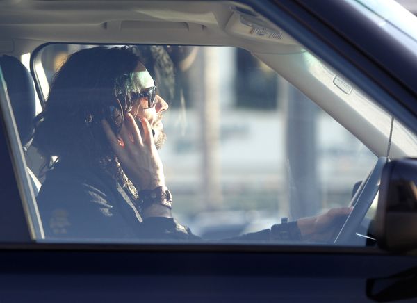 Brand rozmawia przez komórkę i dłubie w nosie za kierownicą