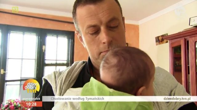 Maria Tymańska uczy Tymona, jak nosić dziecko w chuście