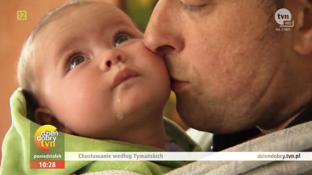 Maria Tymańska uczy Tymona, jak nosić dziecko w chuście