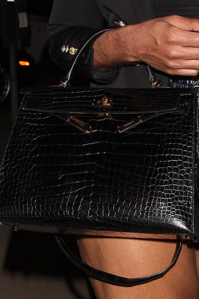 Syn Magica Johnsona w wysokich SZPILKACH przegina się przed restauracją