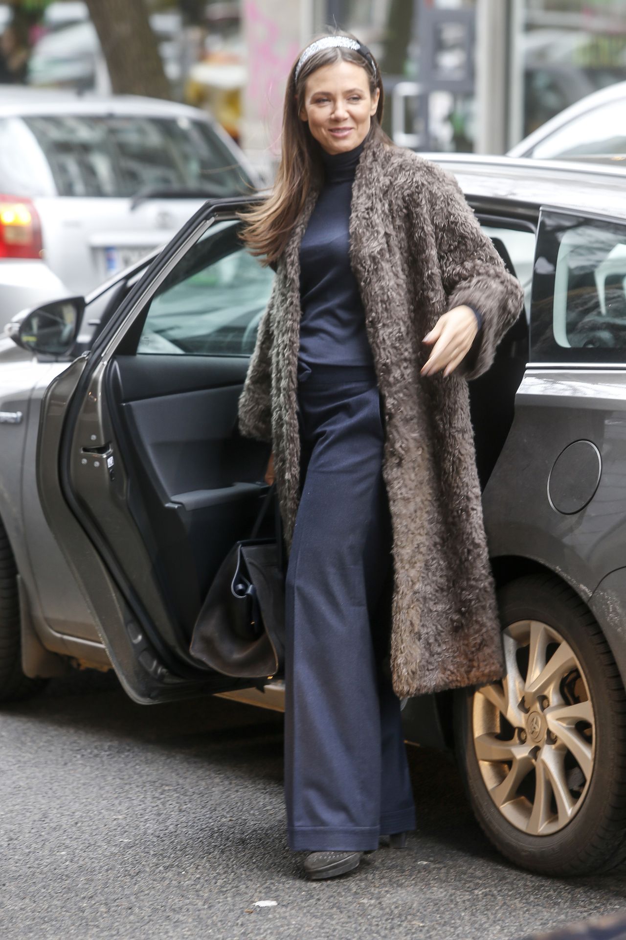 Kinga Rusin w płaszczu i spodniach dzwonach