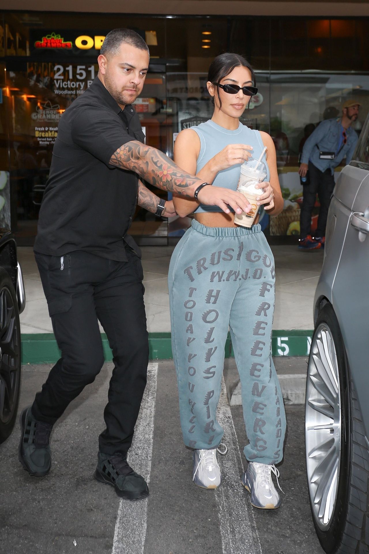 *EXCLUSIVE* Kim Kardashian leaves Burger IM with two milkshakes in hand and midriff on display!
