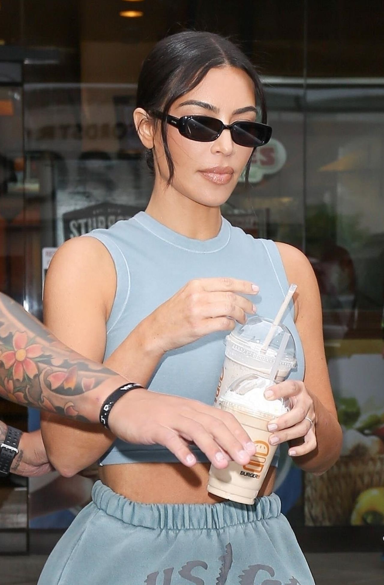 *EXCLUSIVE* Kim Kardashian leaves Burger IM with two milkshakes in hand and midriff on display!