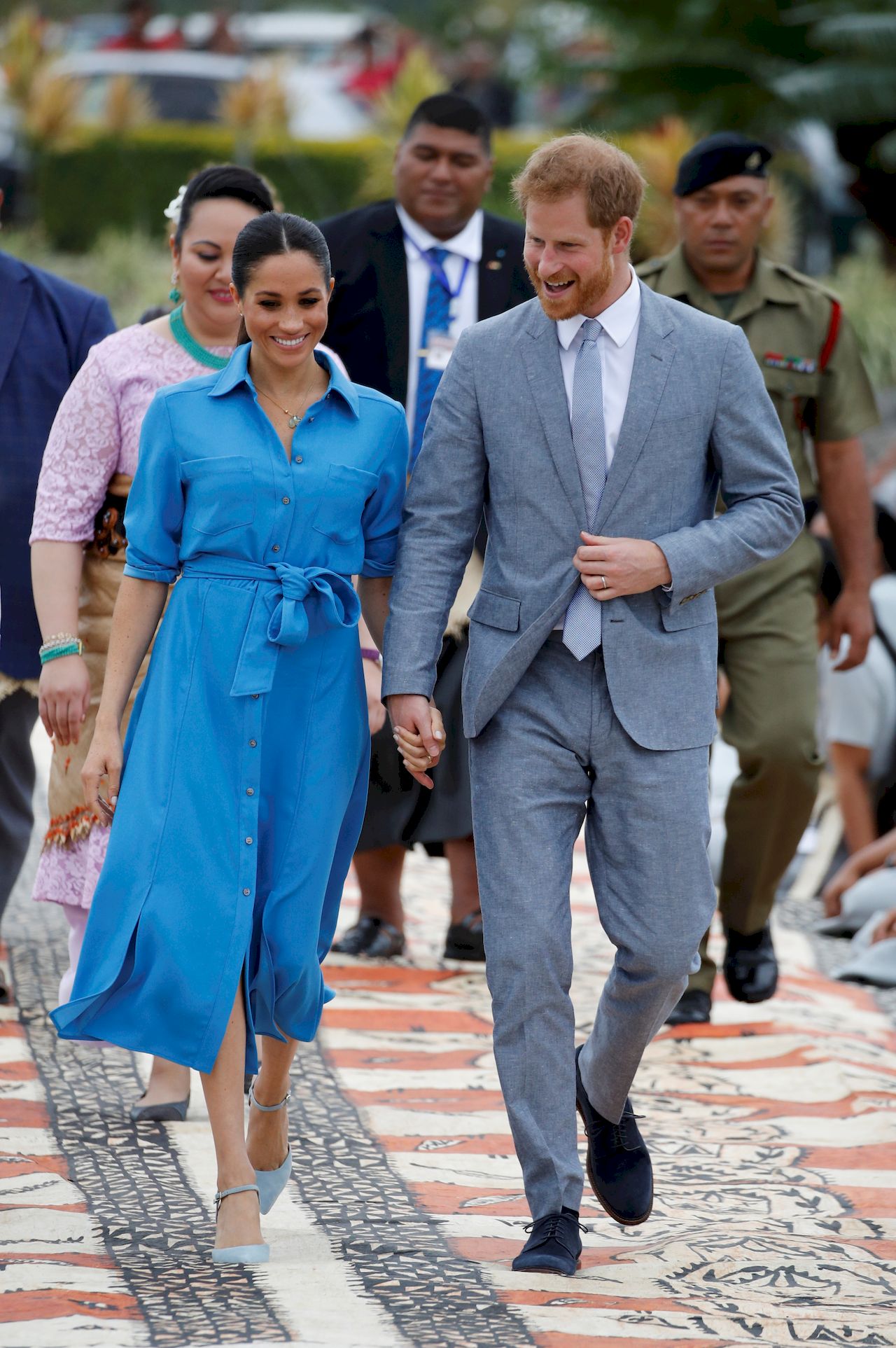 Britain's Prince Harry and Meghan, Duchess of Sussex walk together, ahead of TongaÄôs Princess Angelika, as they depart from Fua'amotu International Airport in Tonga