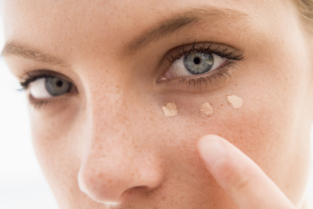 Woman applying concealer Woman applying concealer