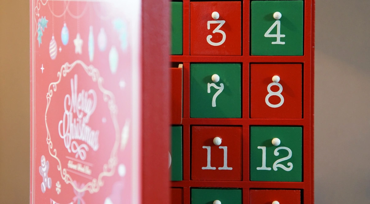 Kalendarze adwentowe z Action na zdjęciu fragment kalendarza adwentowego z ponumerowanymi okienkami w czerwono zielonych kolorach