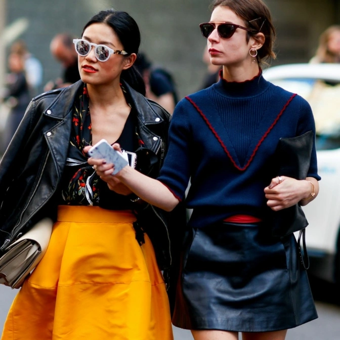 Dwie modnie ubrane kobiety pozują do zdjęcia podczas Copenhagen Fashion Week.