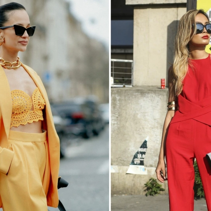Dwie elegancko ubrane kobiety prezentują swoje outfity na ulicy.